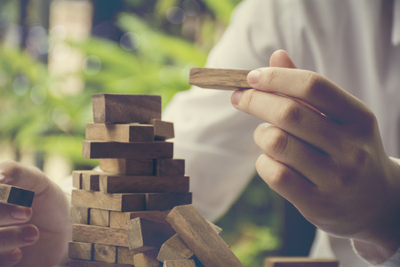 Planning, risk and strategy in business, businessman and engineer gambling placing wooden blockの写真素材