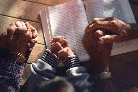 The boy prayed on the table. The family prayed together.の写真素材