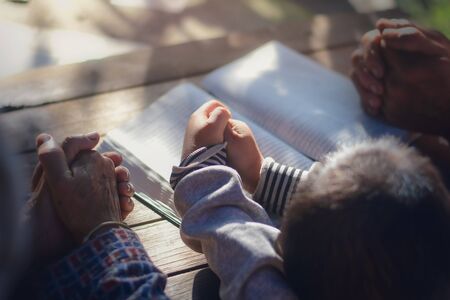 The boy prayed on the table. The family prayed together.の写真素材