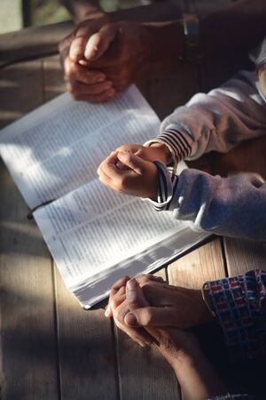 The boy prayed on the table. The family prayed together.の写真素材