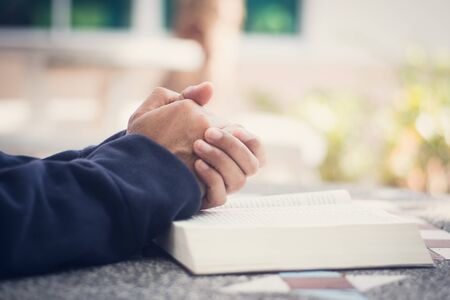 Man holding a bible in her hands and prayingの写真素材