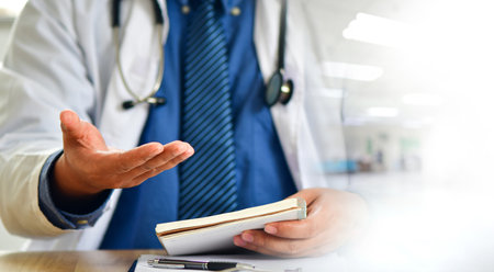 Doctor sits in front of the camera and gives an online consultation to his patient while sitting in the office.の写真素材