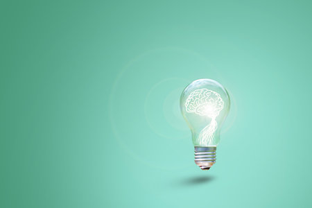 Human brain glowing inside of light bulb on green backgroundの写真素材