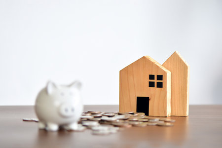 wooden house on stack of coins. Concept of Investment property. Ideas of saving money to build a house, buy a house, do businessの写真素材
