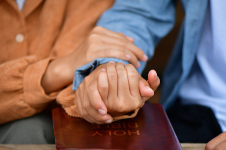 Couple are pray together, hands in prayer together over an open Holy Bible. Christian life crisis prayer to god.の写真素材