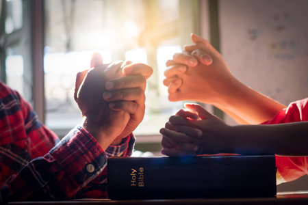 The boy prayed on the table. The family prayed together.の写真素材
