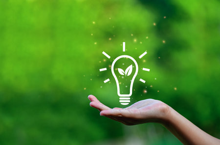 Hand holding light bulb against nature on green leaf with icons energy sources for renewable,の写真素材