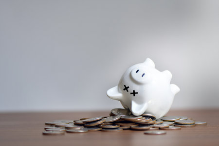 The dead piggy bank lies upside down on coins, Economic crisis, Decrease, layoff, job fired, pay cuts, low cost, collectionの写真素材
