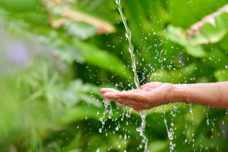 Water pouring on handの写真素材