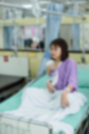 Broken arm patient with arm sling for treatment in the hospital blurred.の写真素材