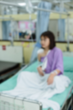 Broken arm patient with arm sling for treatment in the hospital blurred.の写真素材