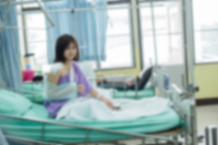 Broken arm patient with arm sling for treatment in the hospital blurred.の写真素材