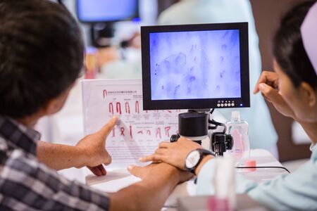Nurses with fingerprint technology to patient.の写真素材