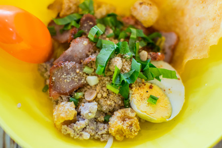 Dry spicy pork noodle in yellow bowlの写真素材