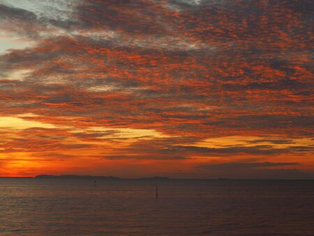Dramatic sunset like fire at the beachの写真素材