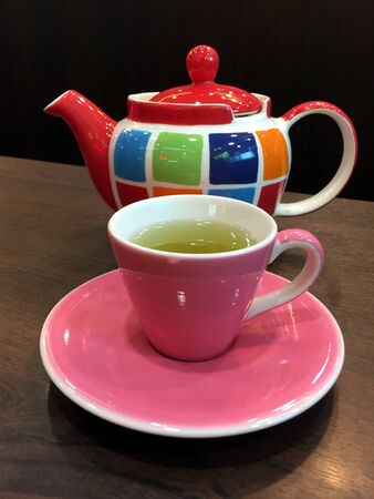 green tea in cup and teapot on wooden tableの写真素材