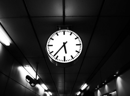 The clock at the railway station show the time while people waiting train to working office white...