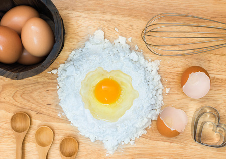 Top view composition flour with egg and ingredients for homemade bakery on wooden backgroundの写真素材