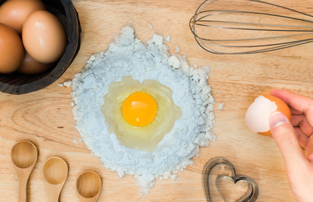 Top view composition flour with egg and ingredients for homemade bakery on wooden backgroundの写真素材
