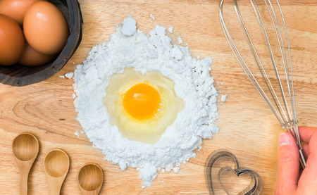Top view composition flour with egg and ingredients for homemade bakery on wooden backgroundの写真素材