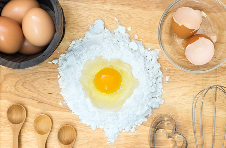 Top view composition flour with egg and ingredients for homemade bakery on wooden backgroundの写真素材