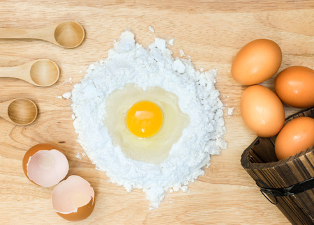 Top view composition flour with egg and ingredients for homemade bakery on wooden backgroundの写真素材