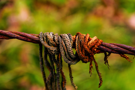 Close-Up Of Rope Wrapped Around Rusty Cable During Autumnの写真素材