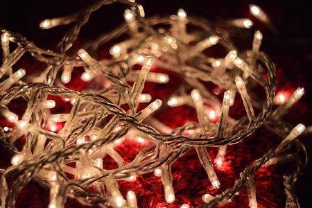 Close-Up Of White Festive Christmas Lights On Red Carpet During Nightの写真素材
