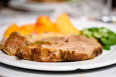 Delicious Pork Steak With Golden Baked Potatoes And Salad On White Plateの写真素材