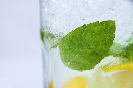 Side Angle View Of Fresh Mojito In Glass With Spearmint Leaves Ice Cubes And Lemon Slicesの写真素材