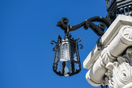 Low Angle View Of Marble Column With Intricate Cast Iron Lamp Against Blue Skyの写真素材