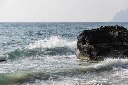 Scenic View Of Ionian Sea With Waves Splashing On Cliff Against Moody Skyの写真素材
