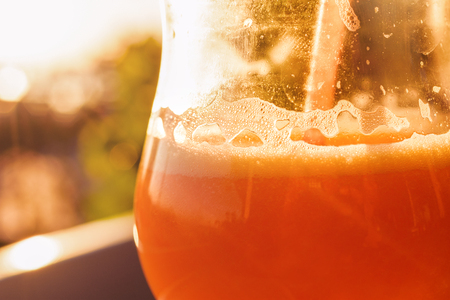 Orange Smoothie In Glass With Straw At Sunsetの写真素材