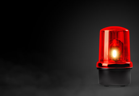 Red siren emergency warning light with black base that are currently on with black background with smoke with clipping pathの写真素材