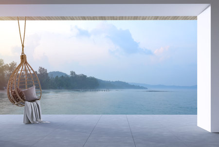 Modern contemporary loft style terrace decorated with rattan egg shaped swing chair overlooking sea view 3d render, There are concrete tile floors ,white wall overlooking beach,sea and mountain.の写真素材