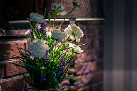 Flowers in a cafe near a brick wall and with a table lamp
