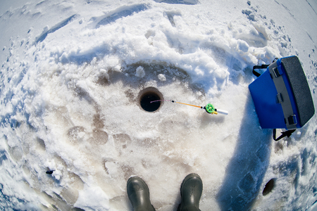 Winter fishing on the lake on a sunny dayの写真素材