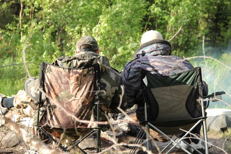

Fishermen on the chairs are heated by the fireの写真素材