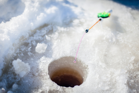 Fishing rod for winter fishing in the snow in the holeの写真素材