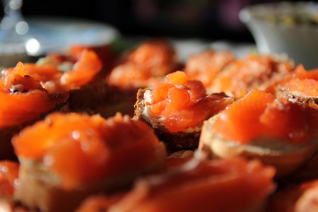 Sandwiches with pink salmon on a plate on a festive tableの写真素材
