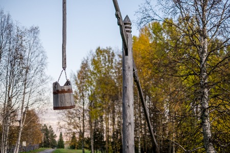 old wooden well with a bucket on a pole in the museum of Malye Korelyの写真素材