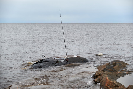 the fishing pole is on a rocky shoreの写真素材