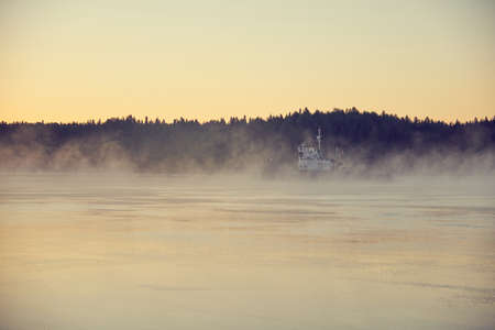 The tug sailing in the fog early in the morning.の写真素材