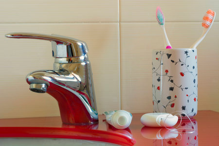Toothbrushes, toothpaste and dental floss on the shelf of the bathroom sinkの写真素材