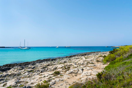 View of Cala Mitjana in Menorca During a summer day with blue sky transparent water, Balearic Islands, Spainの写真素材