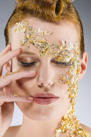 Portrait of a young woman with an elegant gold leaf make-up and closed eyes の写真素材