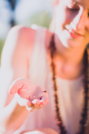Girl looking at a ladybug on her handの写真素材