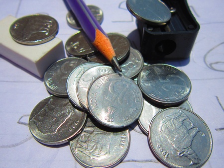 COINS WITH PENCIL AND ERASER DEPICTING RELATIONSHIP BETWEEN STUDY AND EARNING 