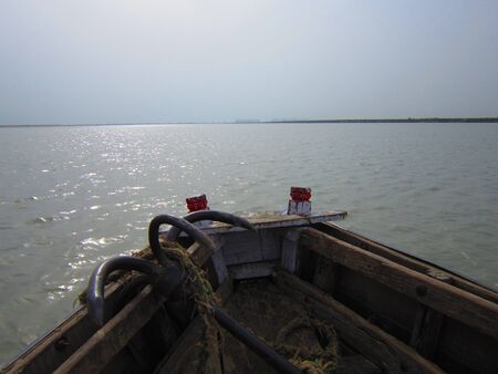 A BOAT AND AN ANCHOR IN A RIVER AT AFTERNOON の写真素材