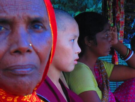 A child monk with local women at a grocery shop at Bodhgaya. Shot at 1807 pm on 11.08.12 at Bodhgaya, Bihar, India, Asia.のeditorial素材